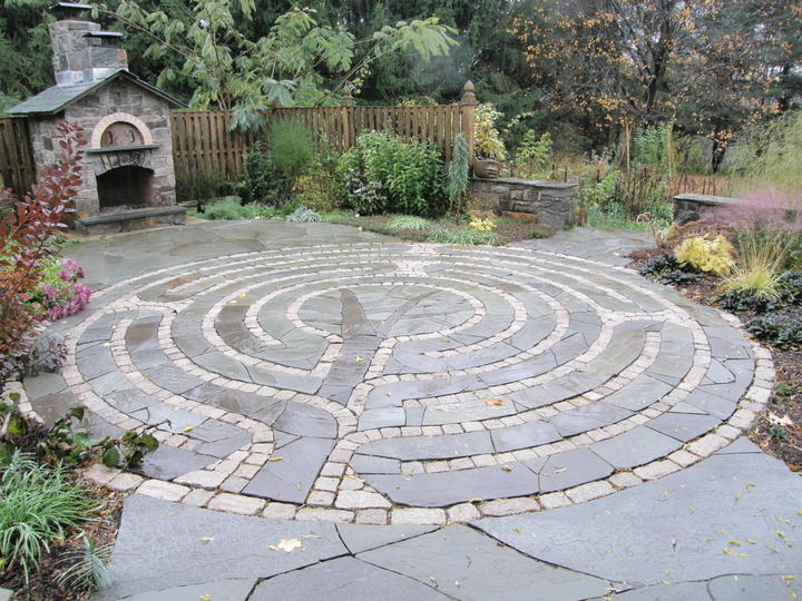 blue stone and cobble stone circular custom patio. custom stone pizza oven